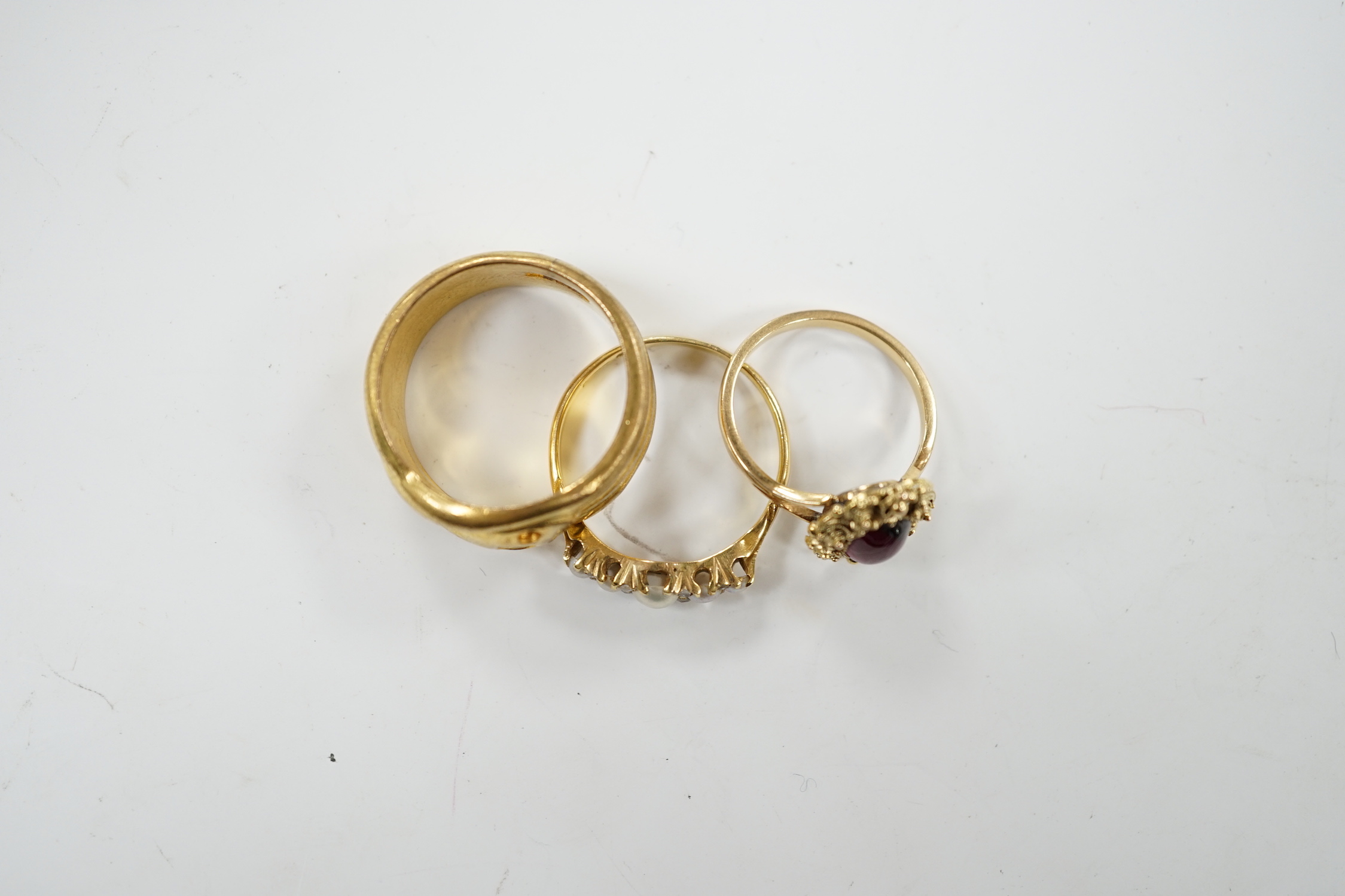 A yellow metal and cabochon garnet set ring, an Edwardian 18ct and graduated split pearl set half hoop ring, with diamond chip spacers and one other ring.